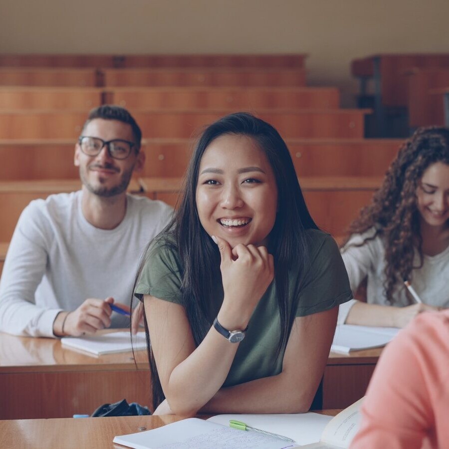 Students smiling in a lecture hall classroom.