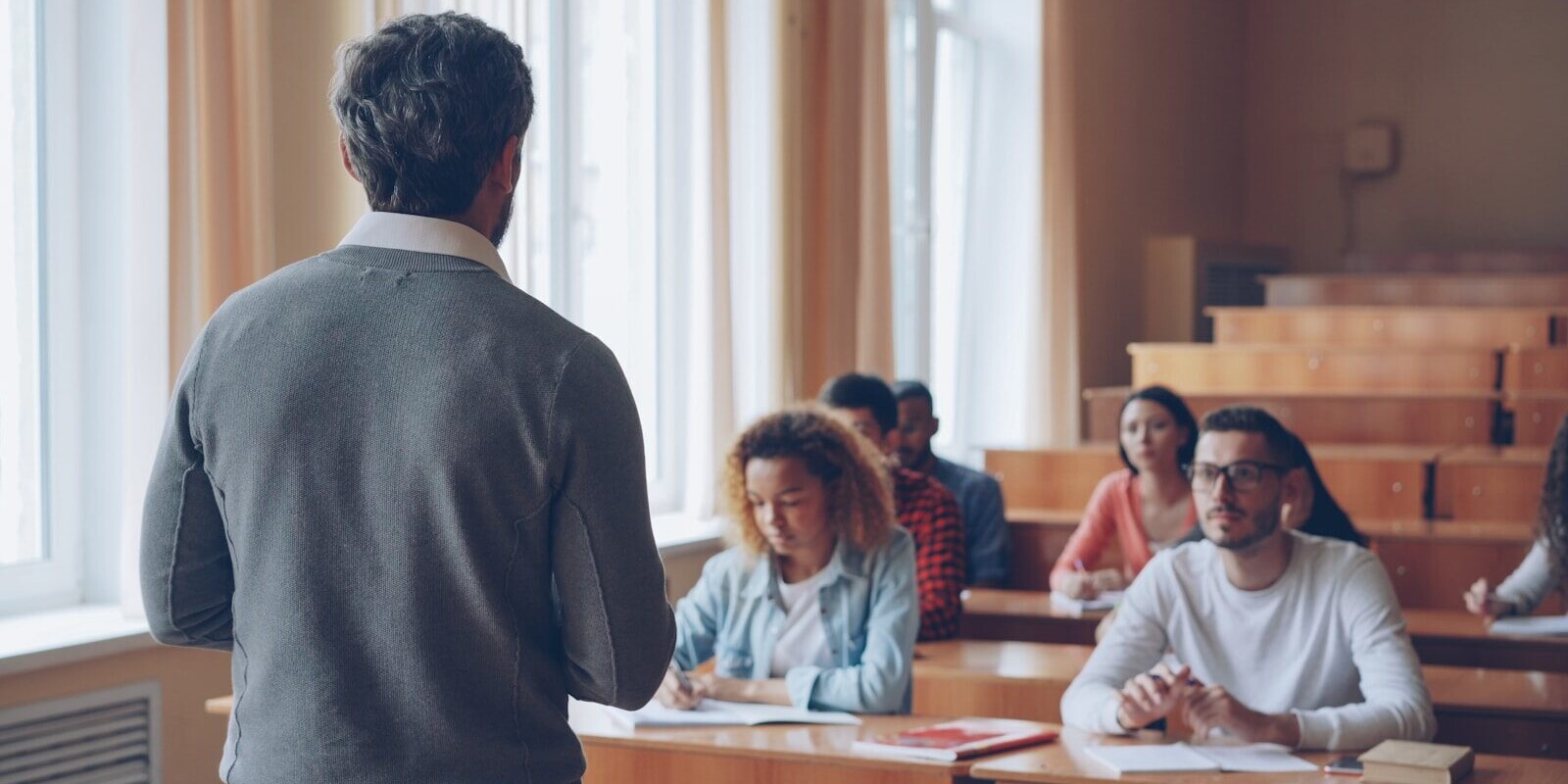 Professor teaching students in a lecture hall.